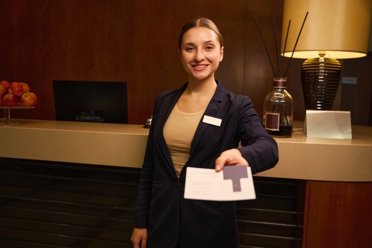 Joyful Woman Receptionist Standing And Giving Someone A Keycard